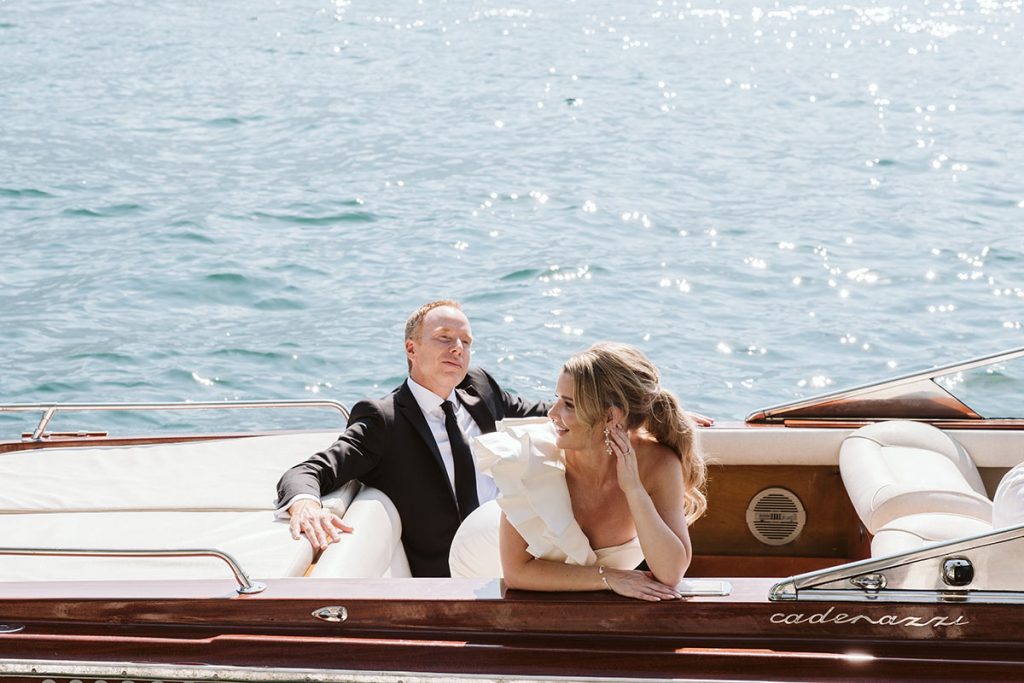 A bride and groom sit in a luxury speedboat on Lake Como, Italy on their Elopement filmed by Story Of Your Day Destination Wedding Videographer