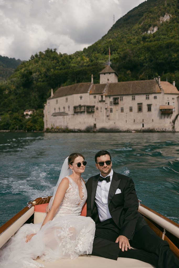 A bride and groom enjoy a speed boat ride on the lake after their wedding at the Fairmont Montreux Palace, Switzerland
