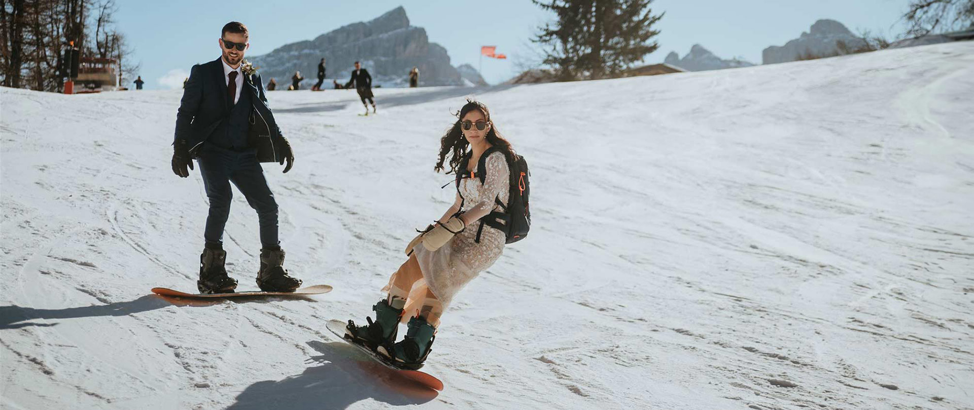 A wedding could snowboard in their wedding outfits during their adventure wedding in the Dolomites