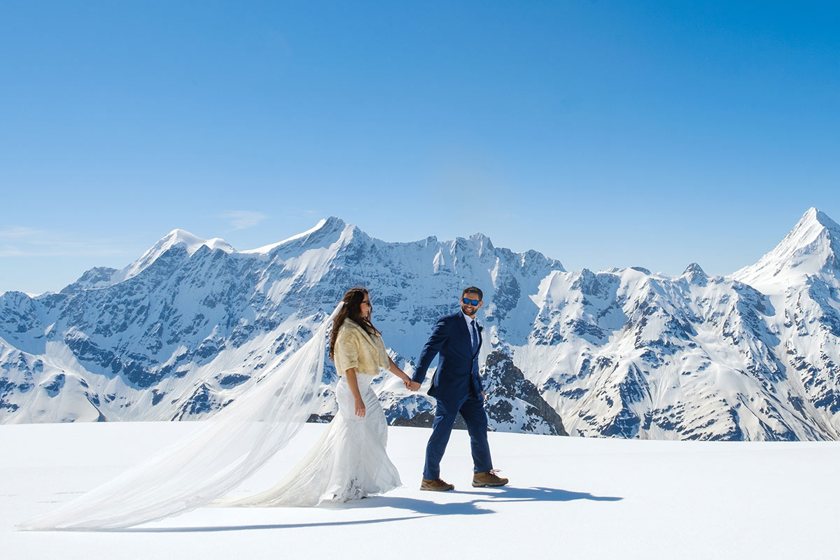 Un couple de mariés se promène main dans la main sur le glacier au-dessus de Lauterbrunnen et Wengen, en Suisse, pour prendre des photos de leur mariage en secret.