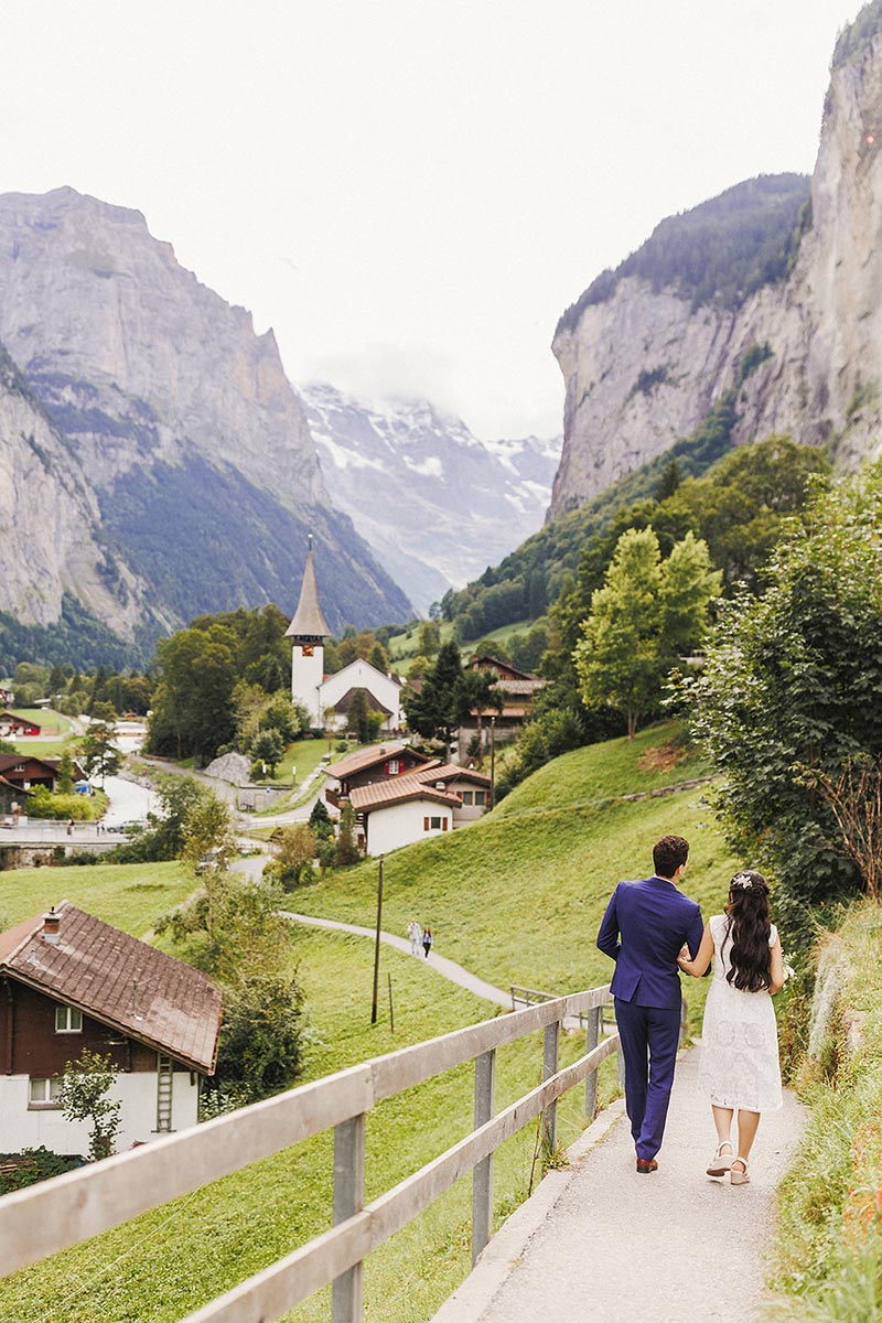 A couple walk down a path towards Lauterbrunnen during their Jungfrau region elopment