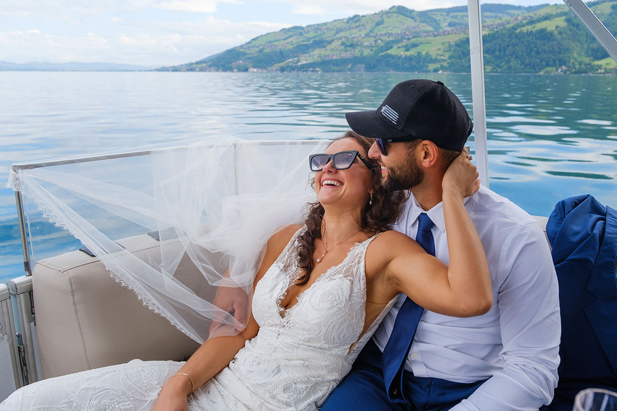 Wedding picture of a bride and groom enjoying a laugh on a classic Swiss boat.
