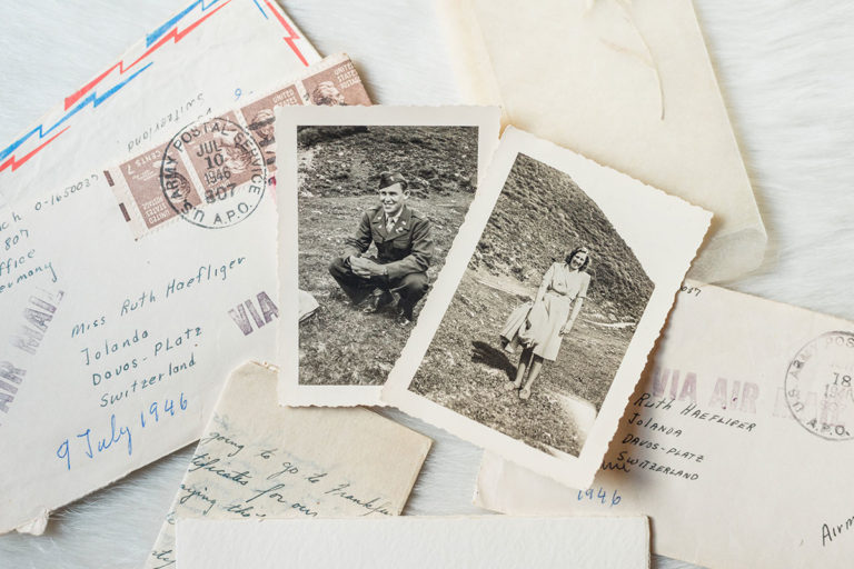 Some old photos and love letters scatttered on a table