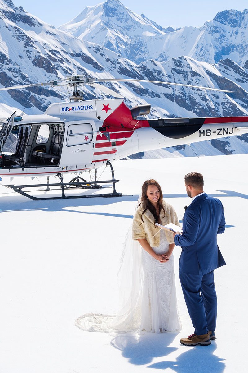 A bride and groom stand on the Petersgrad Glacier above Lauterbrunnen, exchanging vows during their adventure elopement with Story Of Your Day