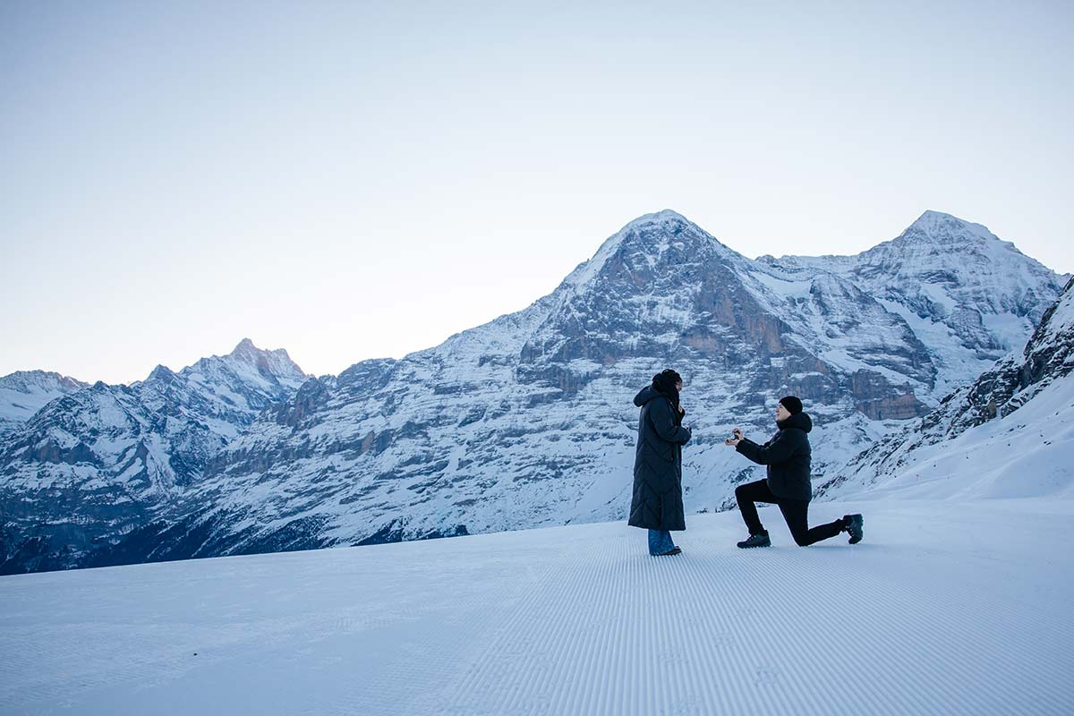 A person kneels and proposes to another with the Eiger in the background, capturing a magical proposal in Wengen 